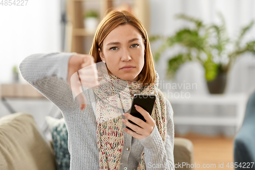 Image of sick woman with smartphone showing thumbs down