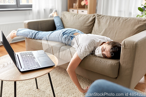 Image of sick bored woman with laptop lying on sofa at home