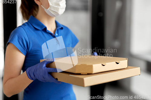 Image of delivery woman in face mask with pizza boxes