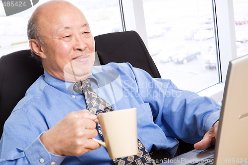 Image of Working senior asian businessman