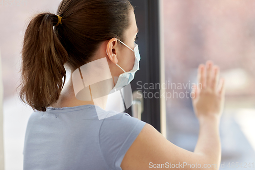 Image of sick young woman wearing protective medical mask