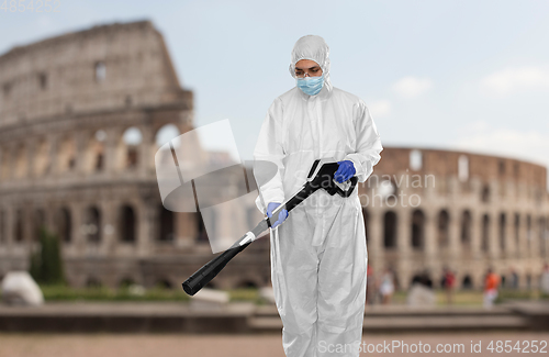 Image of sanitation worker in hazmat with pressure washer