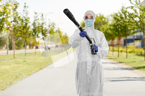 Image of sanitation worker in hazmat with pressure washer