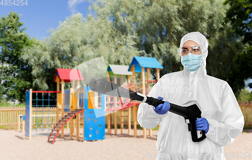 Image of sanitation worker in hazmat with pressure washer