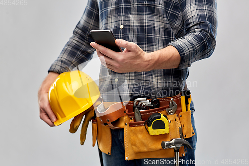 Image of worker or builder with phone and working tools