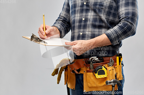 Image of builder with clipboard, pencil and working tools