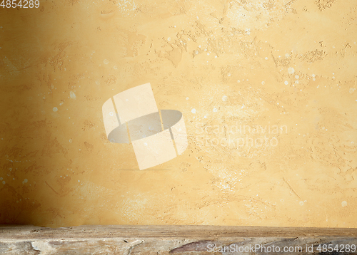 Image of yellow wall and wooden shelf