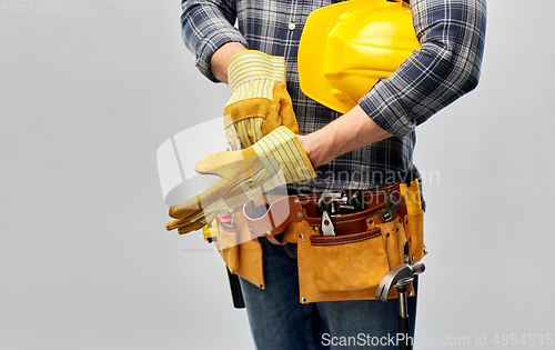 Image of builder with gloves, helmet and working tools