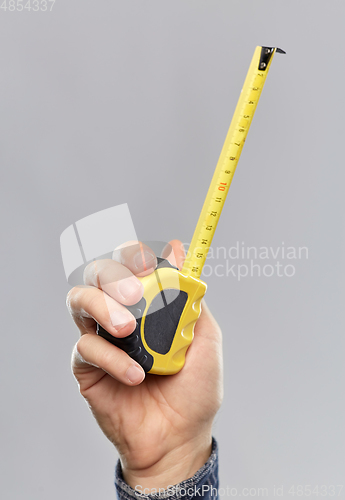 Image of close up of builder's hand holding building ruler