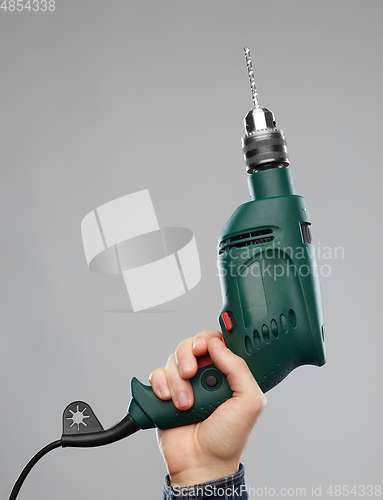 Image of close up of builder's hand holding drill