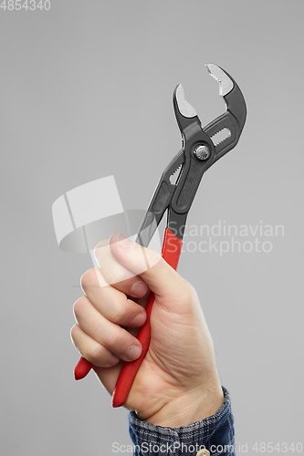 Image of close up of builder's hand holding wrench