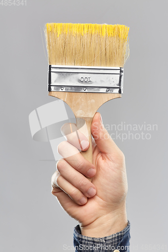 Image of close up of builder's hand holding paint brush