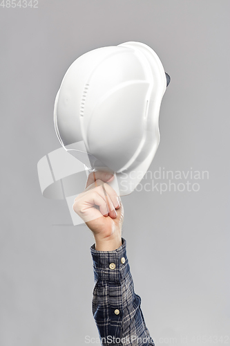 Image of close up of builder's hand holding helmet