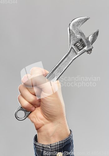 Image of close up of builder's hand holding wrench