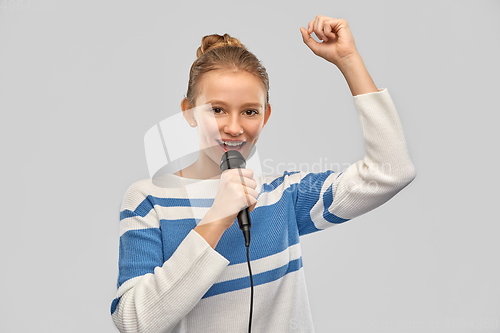 Image of smiling teenage girl with microphone singing