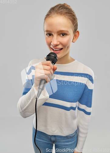 Image of smiling teenage girl with microphone singing