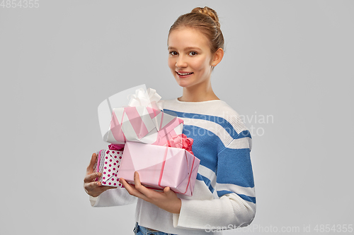 Image of smiling teenage girl in pullover with gift box
