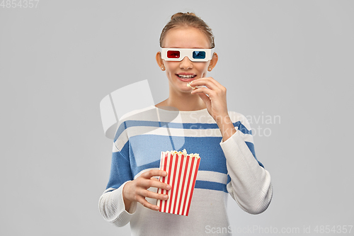 Image of teenage girl in 3d movie glasses eating popcorn