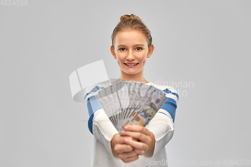 Image of smiling teenage girl with dollar money banknotes