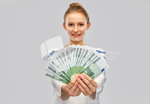 Image of close up of smiling teenage girl with euro money