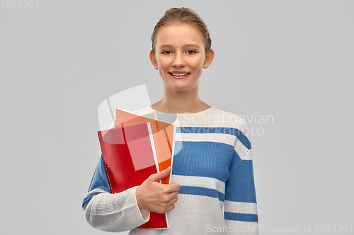 Image of happy smiling teenage student girl with notebooks