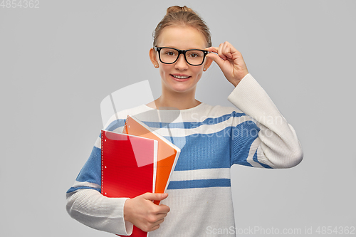 Image of happy smiling teenage student girl with notebooks