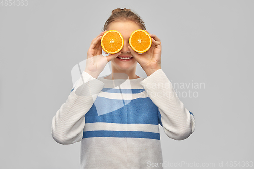 Image of smiling teenage girl with oranges instead of eyes