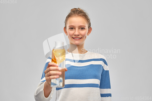 Image of teenage girl with glass bottle of fruit water