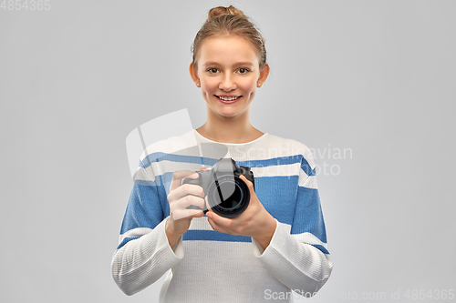 Image of smiling teenage girl r with digital camera