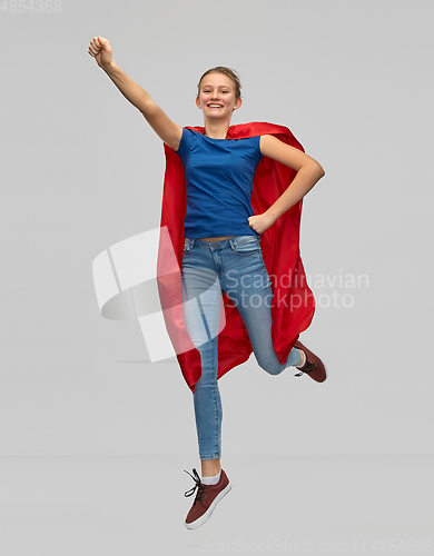 Image of smiling teenage girl in red superhero cape jumping