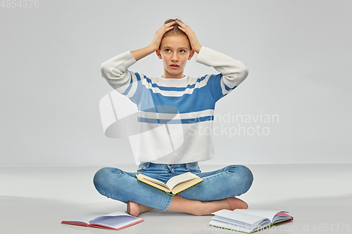 Image of stressed teenage student girl with books