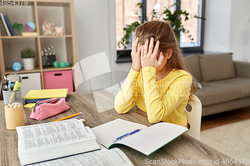 Image of stressed little student girl learning at home