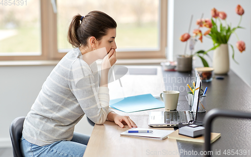 Image of woman with laptop working at home office