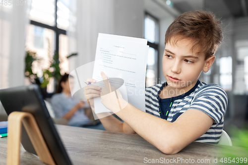 Image of student boy with tablet computer learning at home