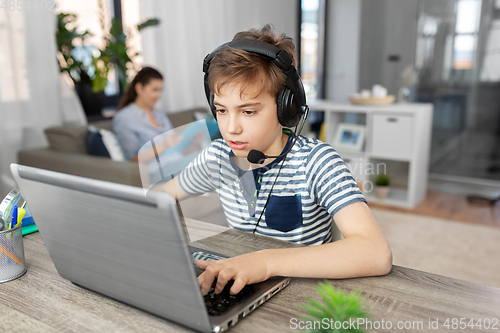 Image of boy with laptop and headphones at home