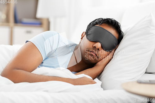 Image of indian man in eye mask sleeping in bed at home