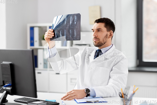 Image of male doctor with x-ray of spine at hospital