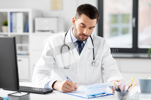 Image of male doctor with clipboard at hospital