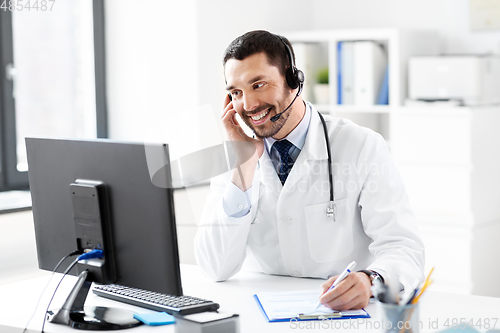 Image of happy doctor with computer and headset at hospital