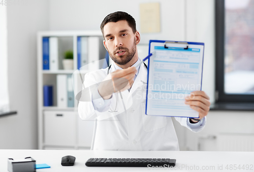 Image of doctor with clipboard having video call at clinic