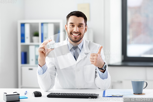 Image of doctor with medicine showing thumbs up at hospital