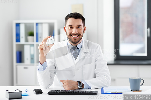 Image of smiling male doctor with medicine at hospital