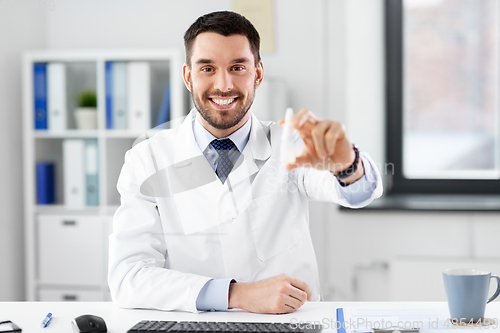 Image of smiling male doctor with medicine at hospital