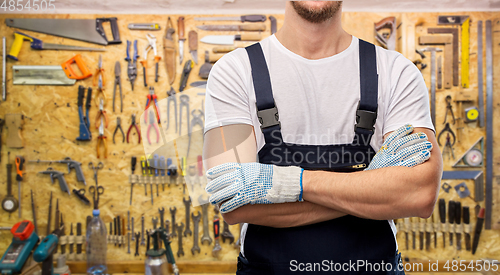 Image of close up of male builder in overall and gloves