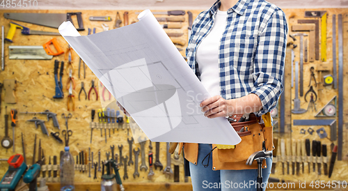 Image of female builder with blueprint and working tools