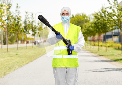 Image of sanitation worker in hazmat with pressure washer