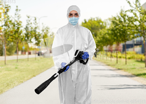 Image of sanitation worker in hazmat with pressure washer