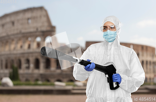 Image of sanitation worker in hazmat with pressure washer