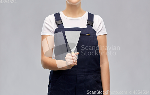 Image of close up of female builder with putty knife