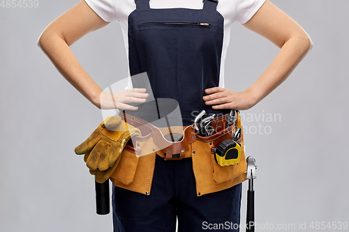 Image of woman or builder with working tools on belt